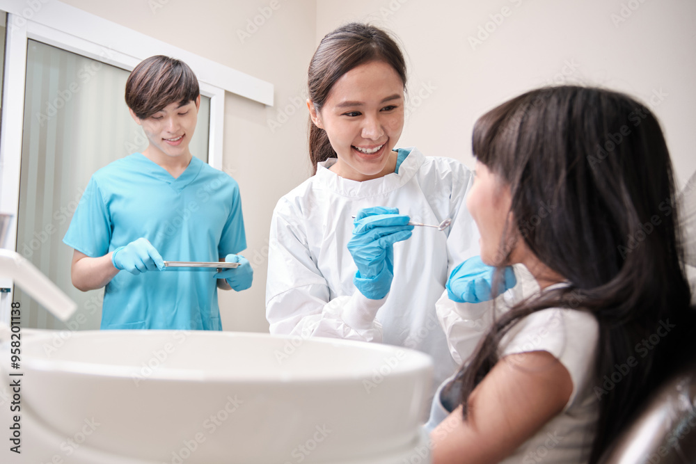 Asian female pediatric dentist and assistant check and examination a little girl's caries teeth in dental clinic, well-being hygiene, and professional orthodontic healthcare work in kid hospital. Asian female pediatric dentist and assistant check and examination a little girl's caries teeth in dental clinic, well-being hygiene, and professional orthodontic healthcare work in kid hospital.
