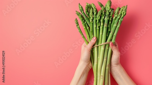 Woman hands holding a bunch of fresh asparagus.