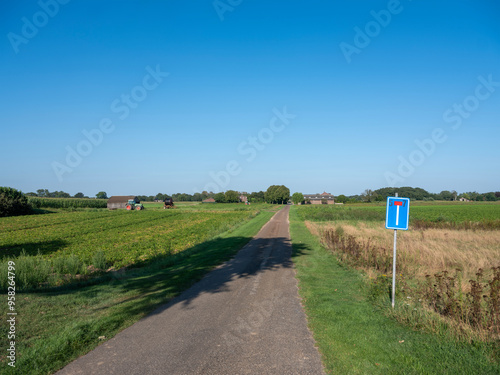 dead end country road with field and farm in national park maasduinen