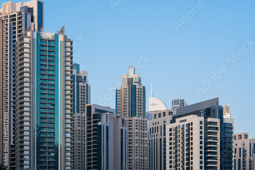 Large residential concrete tower buildings in city, huge skyscrapers in Dubai, Arab architectural design