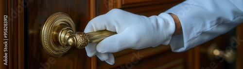 Bellhop's hand wearing white glove grasping hotel door handle, luxury hospitality close-up, attention to detail and service quality photo