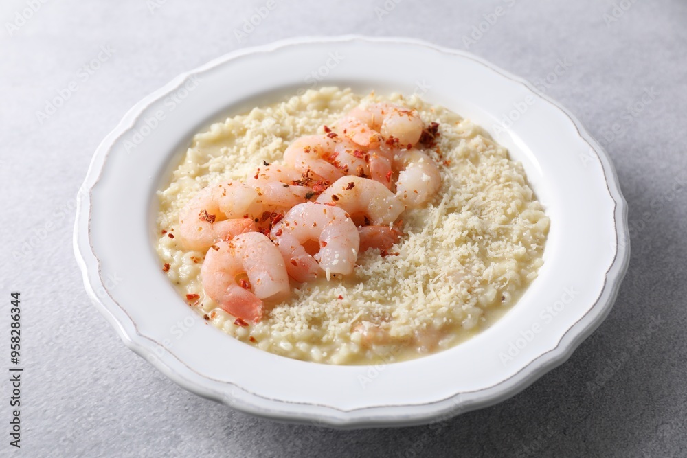 Delicious risotto with shrimps and cheese on light grey table, closeup Delicious risotto with shrimps and cheese on light grey table, closeup