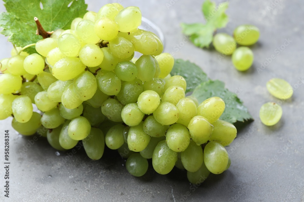 Fresh ripe grapes on grey table, closeup Fresh ripe grapes on grey table, closeup