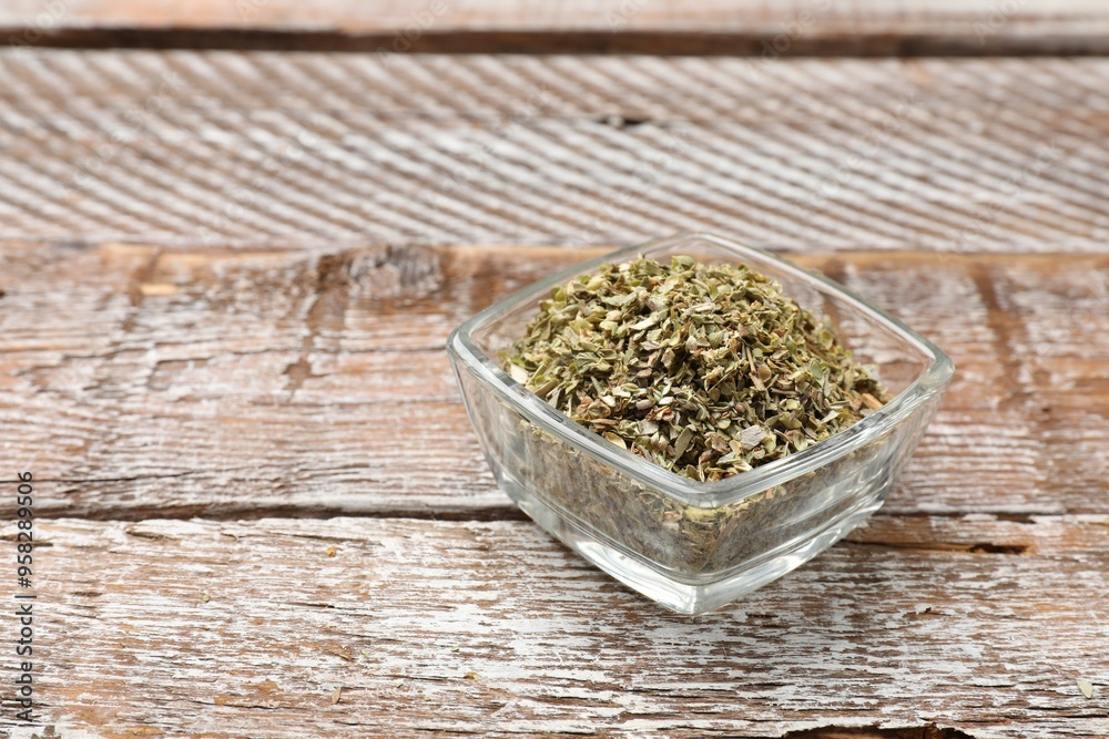 Dried oregano in bowl on wooden table, closeup. Space for text Dried oregano in bowl on wooden table, closeup. Space for text