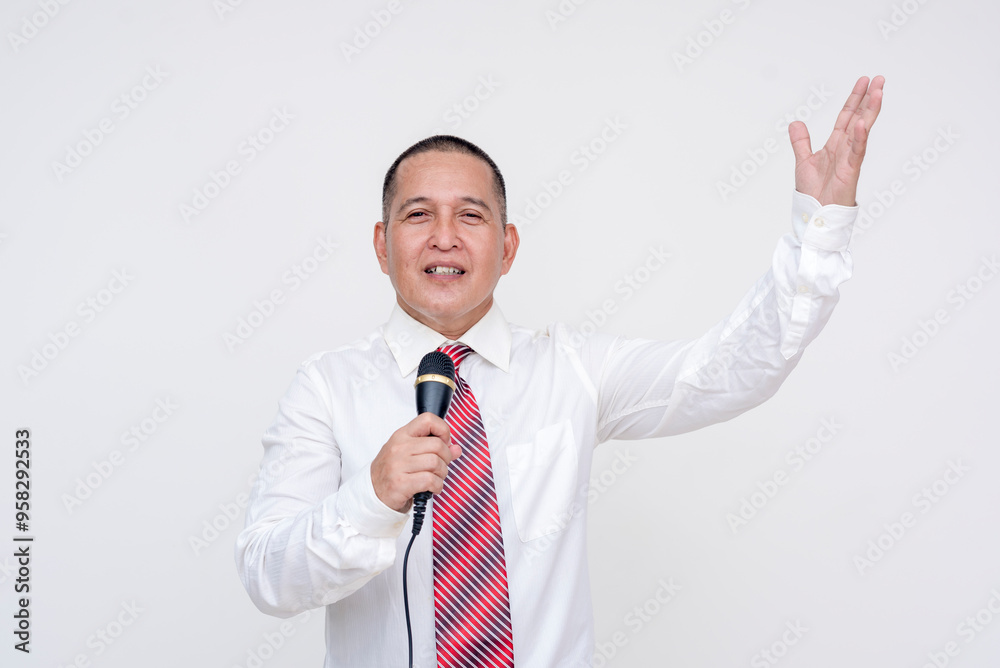 A local middle aged asian politician giving a speech with microphone in hand and making animated gestures. Campaigning of reelection. Set against a white background. A local middle aged asian politician giving a speech with microphone in hand and making animated gestures. Campaigning of reelection. Set against a white background.