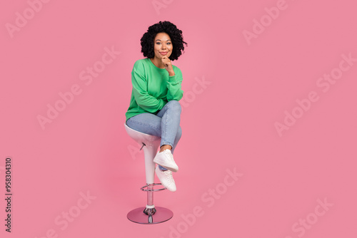 Full length photo of adorable thoughtful girl wear green sweatshirt sititng bar chair arm chin empty space isolated pink color background photo