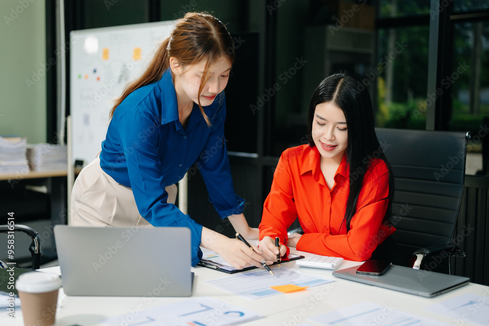 Fototapeta premium Asian business colleague business presents and explains and using laptop and tablet. Teamwork, financial