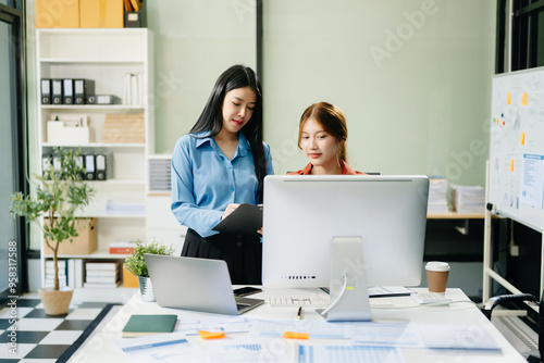 Asian business colleague business presents and explains and using laptop and tablet. Teamwork, financial