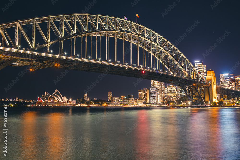 Naklejka premium Cityscape image of Sydney, Australia with Harbour Bridge and Opera house during night time.