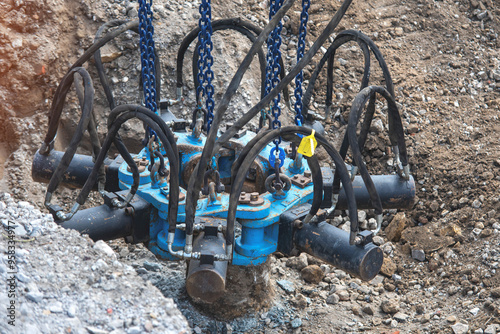 Builders using hydraulic pile cropper excavator attachment to cut off top of pile at a Construction Site on a Sunny Day photo