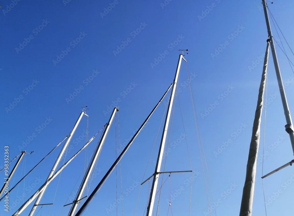 Fototapeta premium Masts of sailboats against clear blue sky