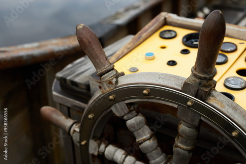 A close-up view of a wooden ship's wheel on a boat