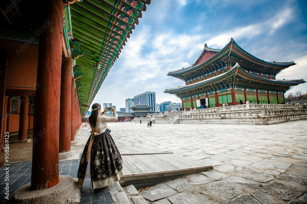 Tourists in national clothes walk in Gyeongbokgung Palace