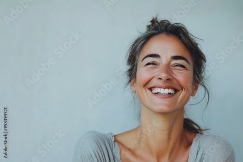 Happy woman laughing against plain background