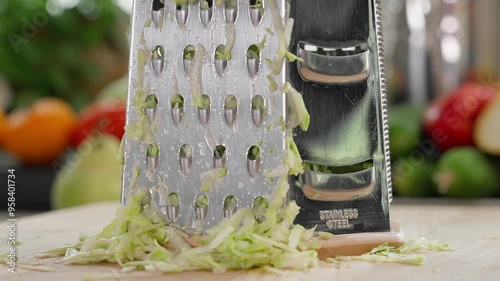 Macro. Zucchini is grated manually in the kitchen and the results of grating are shown, on a wooden board. Zucchini dish, zucchini recipe, vegetarian food, vegetables. Front view, close-up photo