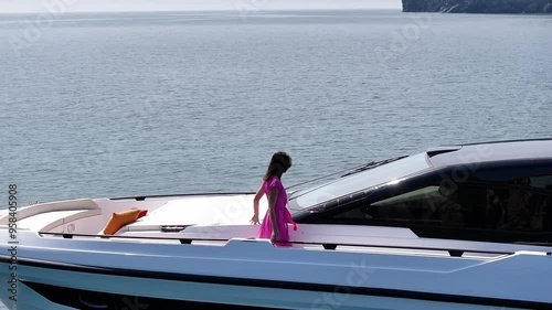 beautiful woman walks aboard a yacht