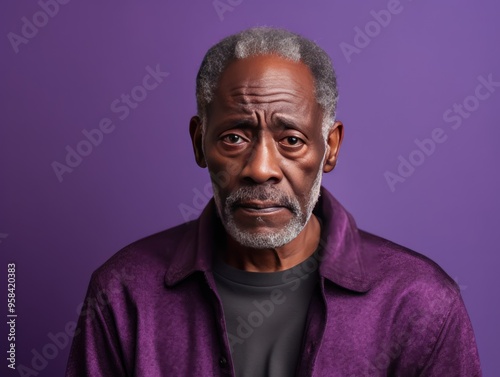 Purple background sad black American independent powerful man. Portrait of older mid-aged person beautiful bad mood expression isolated