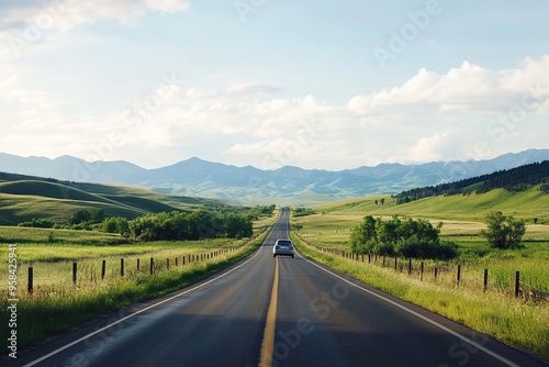 Car driving on open road with scenic mountains under blue sky