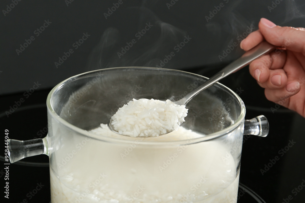 Woman taking boiled rice from pot, closeup Woman taking boiled rice from pot, closeup