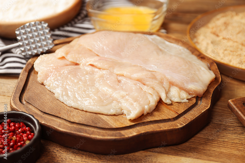 Making schnitzels. Raw meat and other ingredients on wooden table, closeup Making schnitzels. Raw meat and other ingredients on wooden table, closeup