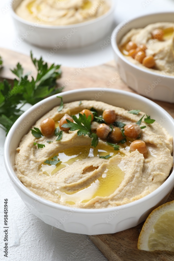 Delicious hummus with olive oil, chickpeas and parsley served on light table