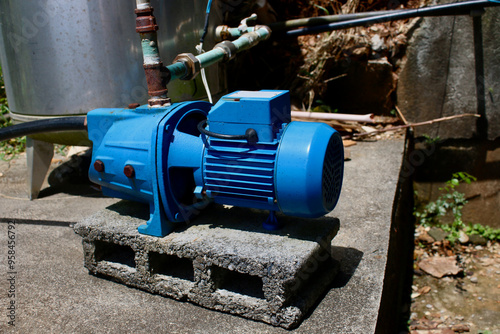 Water pump on concrete. Water pump installed in the backyard of a country house.