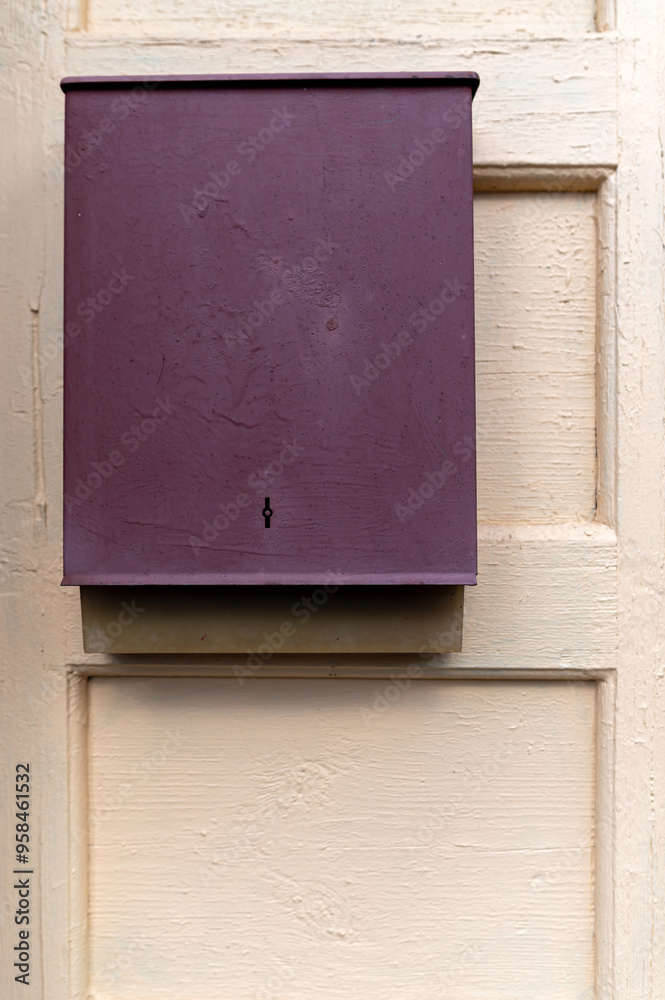A purple mailbox mounted on a wooden door in a quaint residential area during the daytime A purple mailbox mounted on a wooden door in a quaint residential area during the daytime