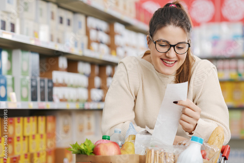 Happy customer holding a long grocery receipt