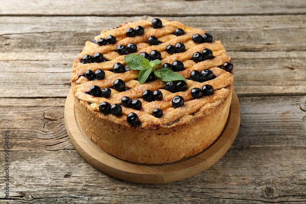 Delicious homemade blueberry pie with mint on wooden table