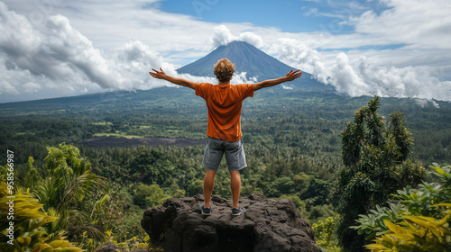 Strong and confident man standing on to a mountain. Fit active lifestyle concept. Positive man celebrating on mountain top, with arms raised up, Goal, successful, achievement. Strong and confident man