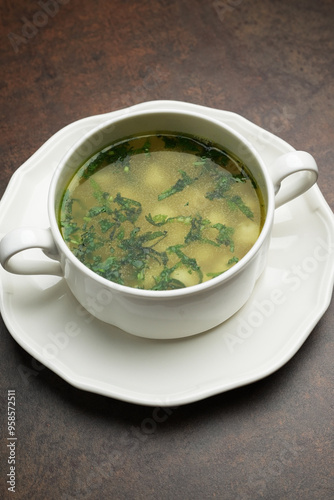 Azerbaijan dushbara soup in a white bowl. Dumplings soup with herbs photo