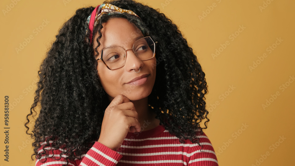 Close-up of young woman thinking, dreaming about something, on yellow background in the studio Close-up of young woman thinking, dreaming about something, on yellow background in the studio