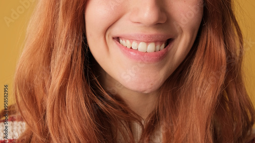 Close-up, female smile on yellow background in studio