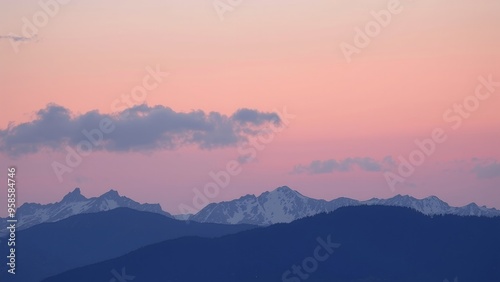 Silhouetted mountain range against a pink and purple sky at sunset.