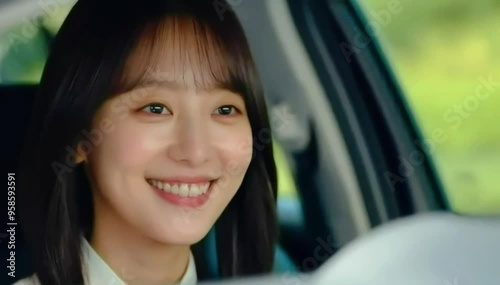 A cheerful woman smiling as she drives her car