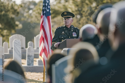 A military officer delivering a speech at a Veterans Day ceremony at a cemetery honoring fallen soldiers and their servic photo