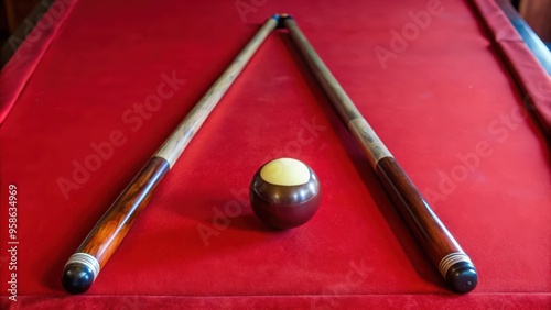 Two Pool Cues Form a Triangle Pointing to a Single Ball on a Red Felt Pool Table photo