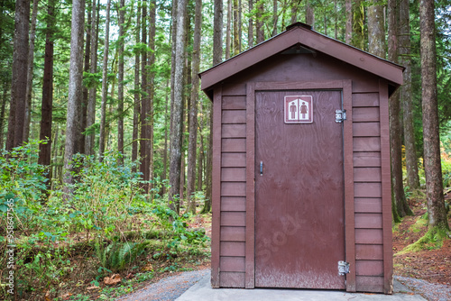 Wooden outdoor toilet in the forest. Public toilet in the park. WC for Men and Women.