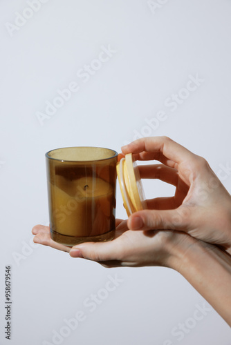 Person holding a candle with lids on top and bottom