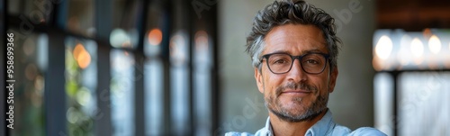 Man with glasses and a beard standing in front of a window, portrait, banner, copy space