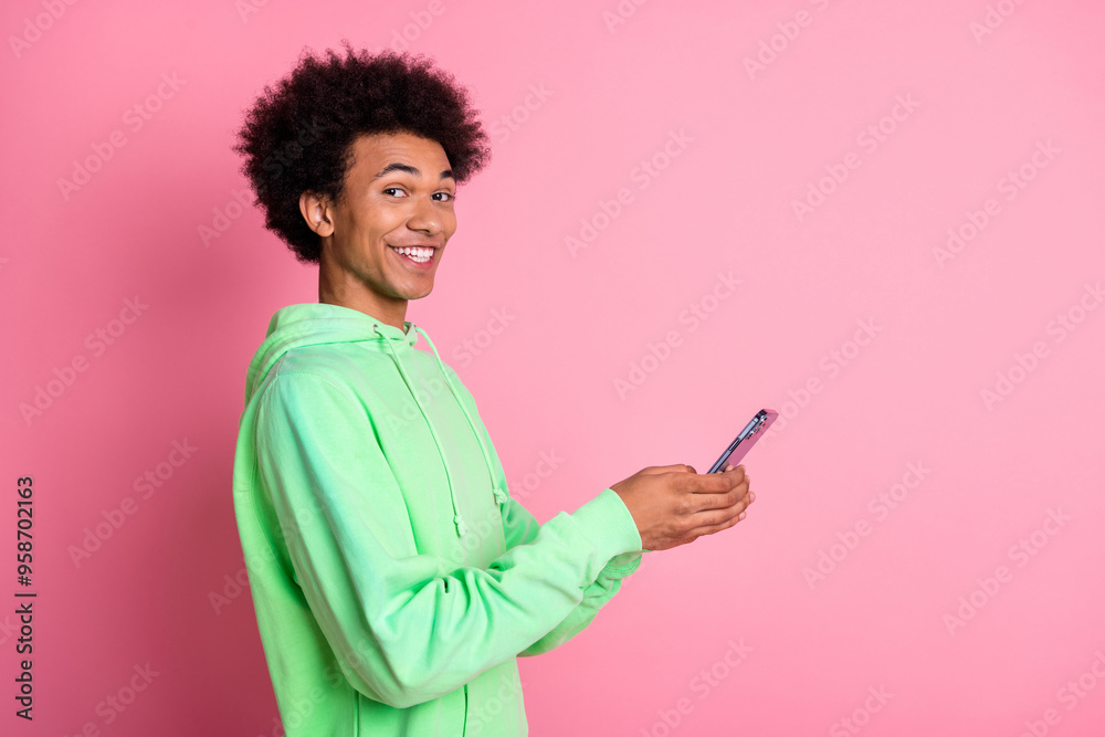 Profile portrait of cool young man phone empty space wear green hoodie isolated on pink color background