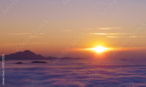 Fototapeta Naklejka Na Ścianę i Meble -  Mount Ori. Sun at sunset with sea clouds on the route of the swallows, Jeandel refuge, Pyrenees of France.