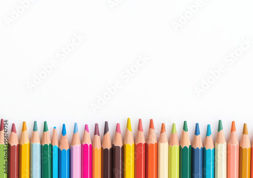 Colorful pencils with sharpened tips arranged in a neat row against a white background, representing creativity and art.