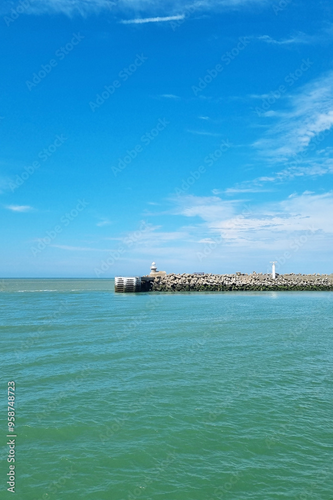 Serene Seaside with Lighthouse Under Clear Blue Sky - Coastal Recreation, Travel Concept Serene Seaside with Lighthouse Under Clear Blue Sky - Coastal Recreation, Travel Concept