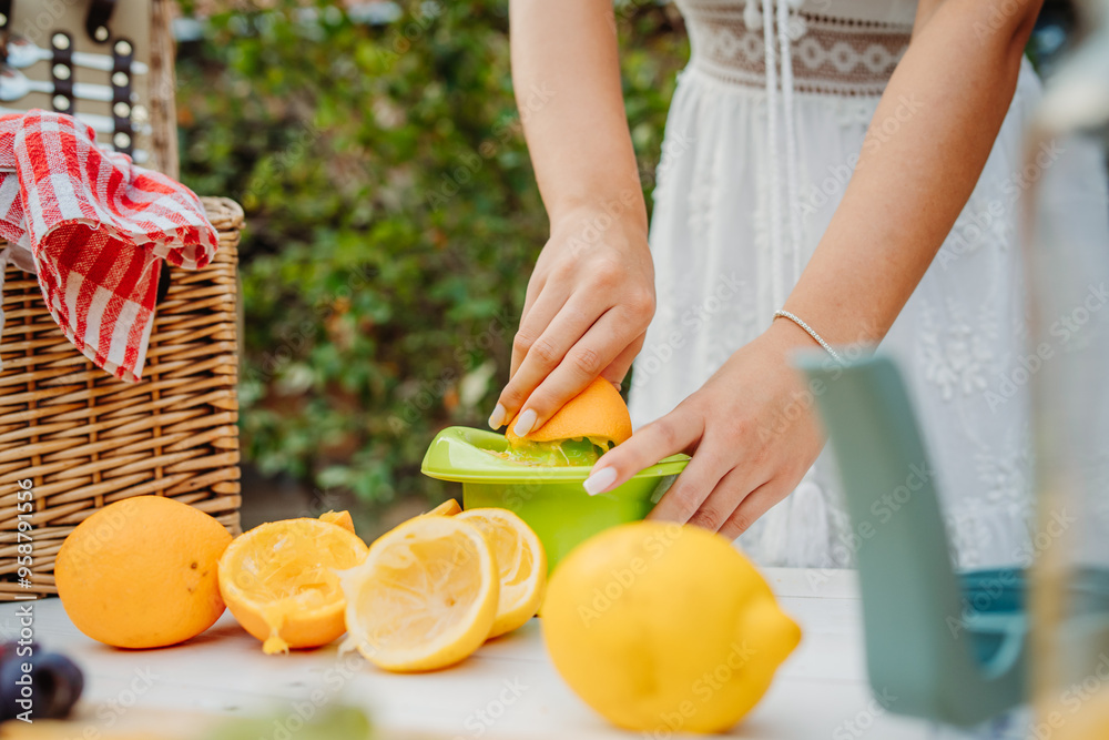 Close up of woman's hands using hand juicer for orange and lemon