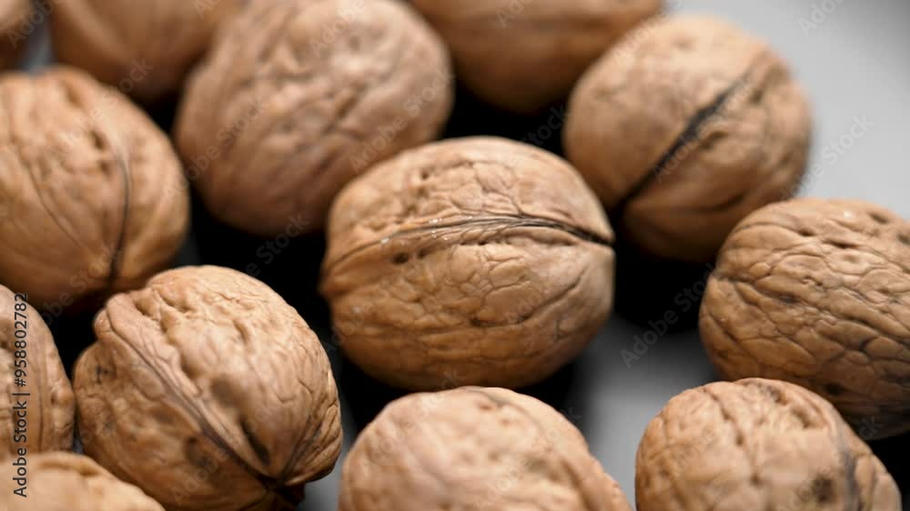 Falling freshly harvested walnut in shell on black ceramic plate close up. Organic fresh nuts Falling freshly harvested walnut in shell on black ceramic plate close up. Organic fresh nuts