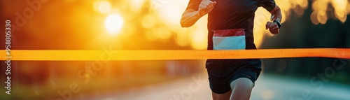 Runner crossing the finish line at sunset during a race, demonstrating victory and achievement in sports with a blurred background. photo