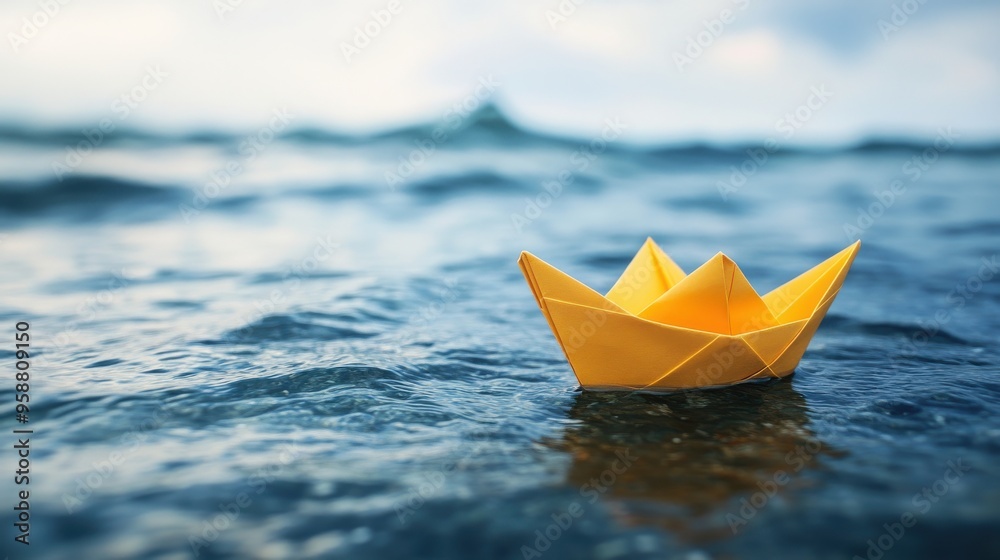 Yellow paper boat floating on calm water, symbol of adventure and exploration.
Yellow paper boat floating on calm water, symbol of adventure and exploration.