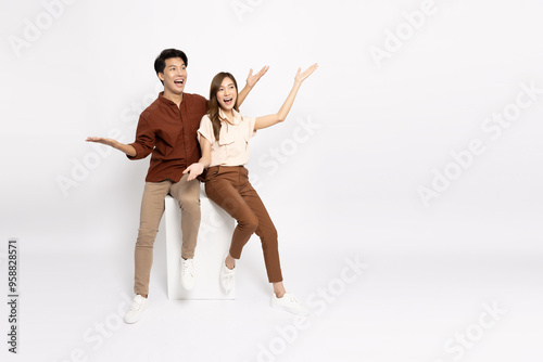 Happy Asian couple presenting or showing open hand palm with copy space for product isolated over white background