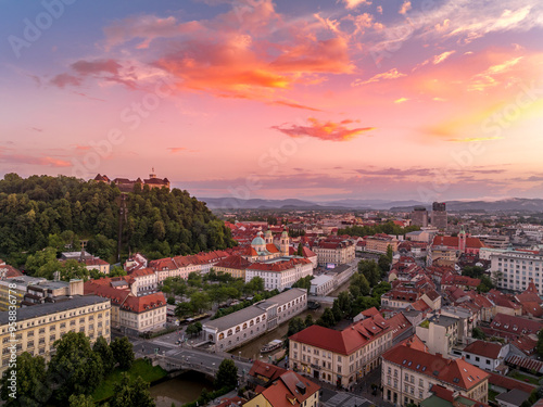 Obraz na płótnie Aerial view of central Ljubljana Slovenia with historic buildings, hilltop castle red roof houses, churches in the Slovenian capital sunset colorful sky w salonie
